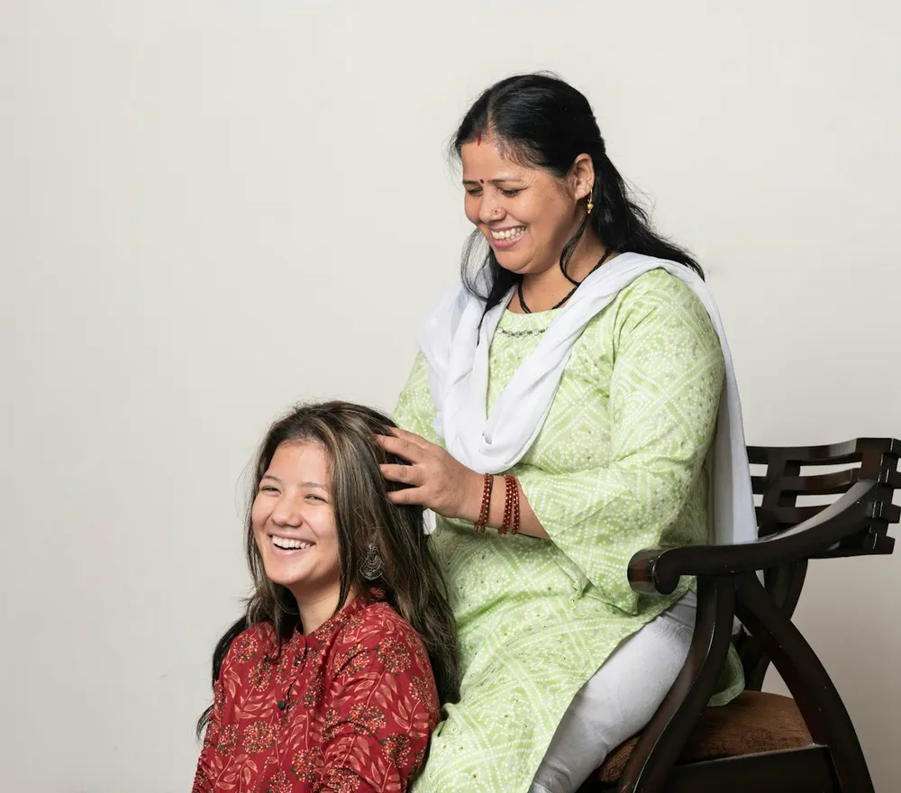 A mother lovingly braiding her grown daughter's hair