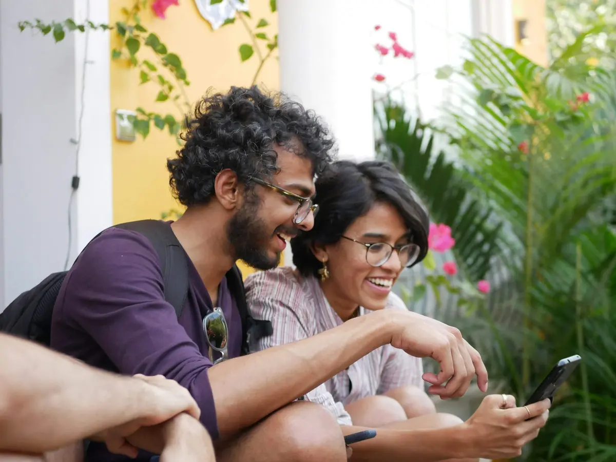 Two people laughing together over a phone